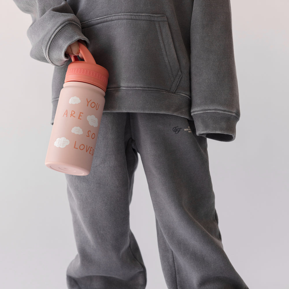 Person wearing a gray tracksuit holding a pink water bottle with text on a light gray background