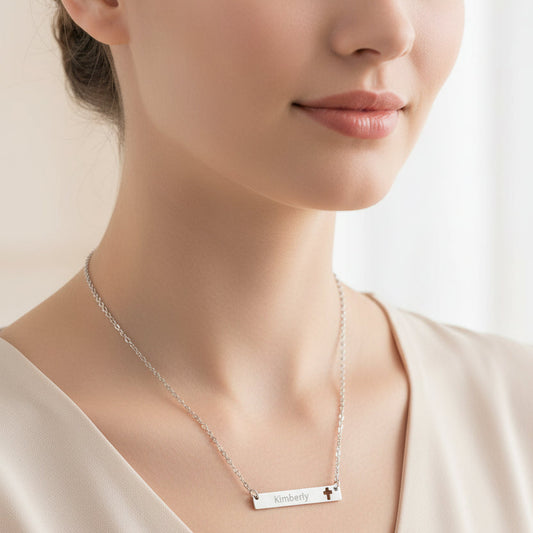Silver necklace with a bar pendant engraved with 'Kimberly' and a cross symbol on a white background.