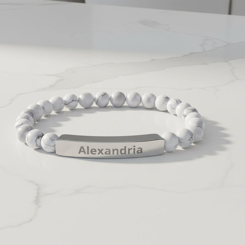 White beaded bracelet with a nameplate on a white background