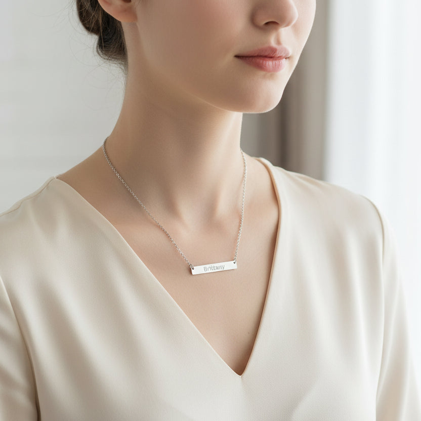 Silver necklace with a bar pendant engraved with 'Brittany' on a white background