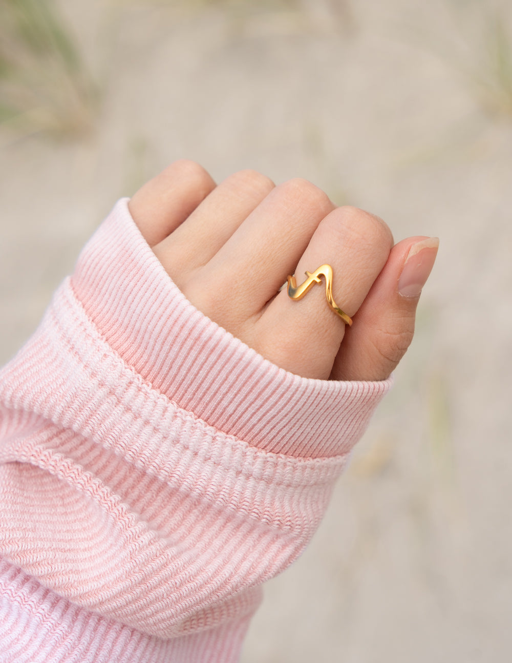 Gold ring on a finger with a blurred natural background