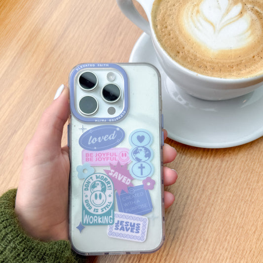 Phone case with motivational phrases held by a hand next to a cup of coffee on a wooden table.