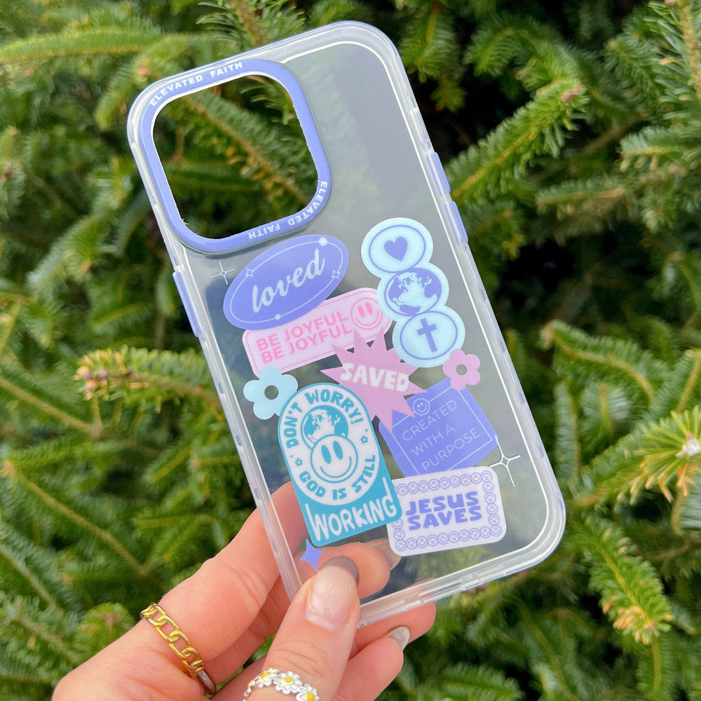 Clear phone case with colorful text and graphics held in front of a green leafy background