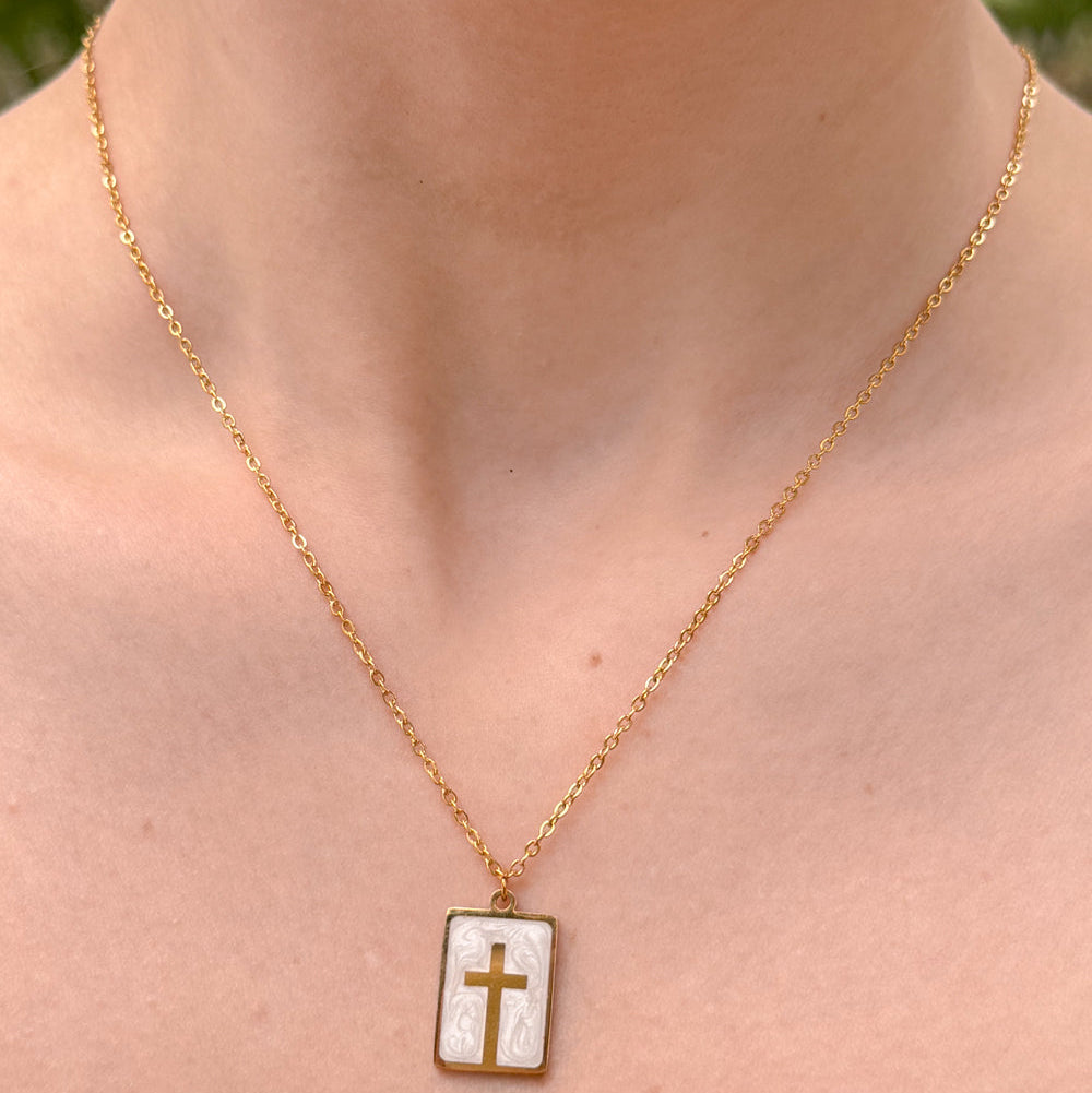 Necklace with a pendant featuring a cross on a person's neck