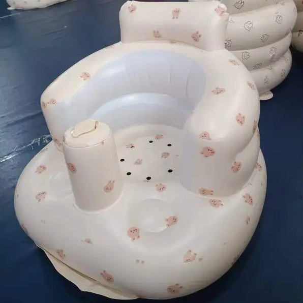 Inflatable baby seat with floral patterns on a blue floor.
