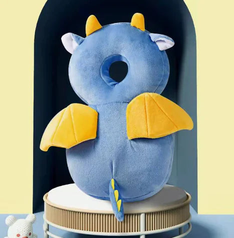 Blue dragon-shaped pillow with yellow wings on a stand against a light yellow background