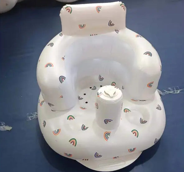 Inflatable baby seat with rainbow pattern on a dark surface